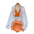 Vacation-ready bikini set for the hot girl summer look: orange cami top, floral print skirt, and sun-protective cardigan – a chic and stylish three-piece outfit