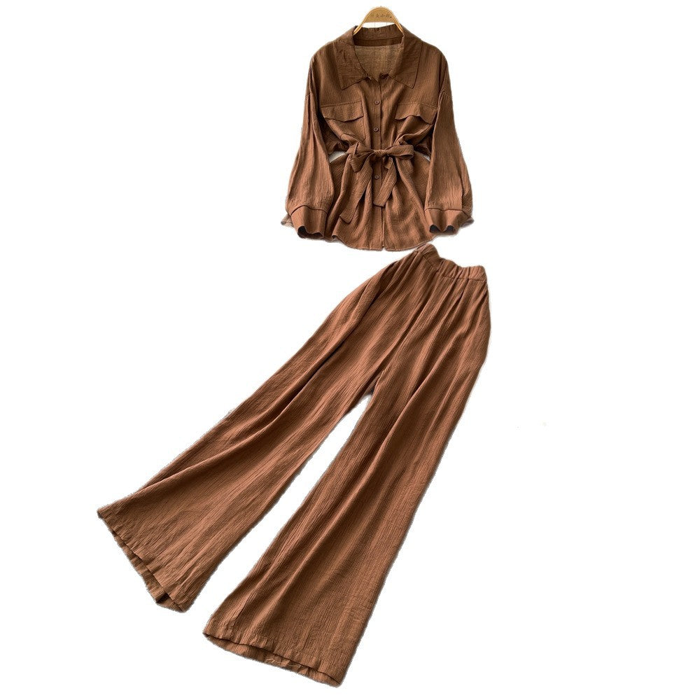 Sophisticated, niche design two-piece set for women: a long-sleeved, tie-waist blouse with a bow detail, paired with high-waisted, wide-leg pants
